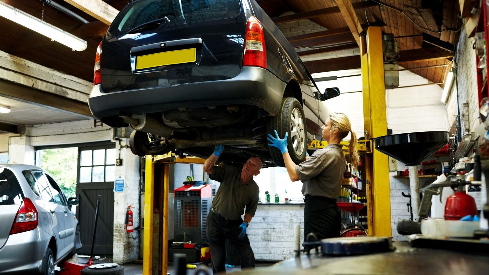Car on a lift being inspected during an MOT test
