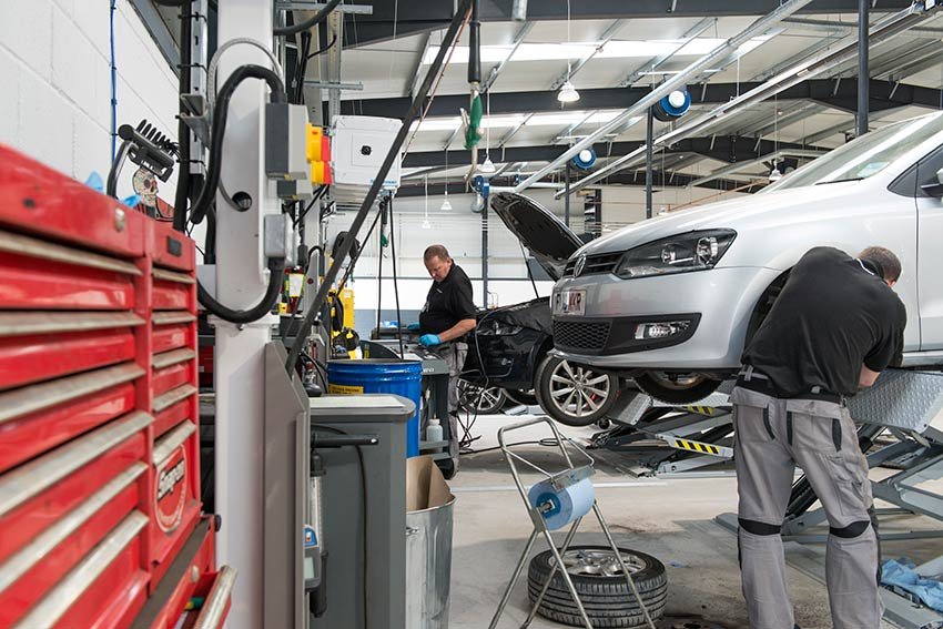 Car undergoing MOT test on a ramp in a garage