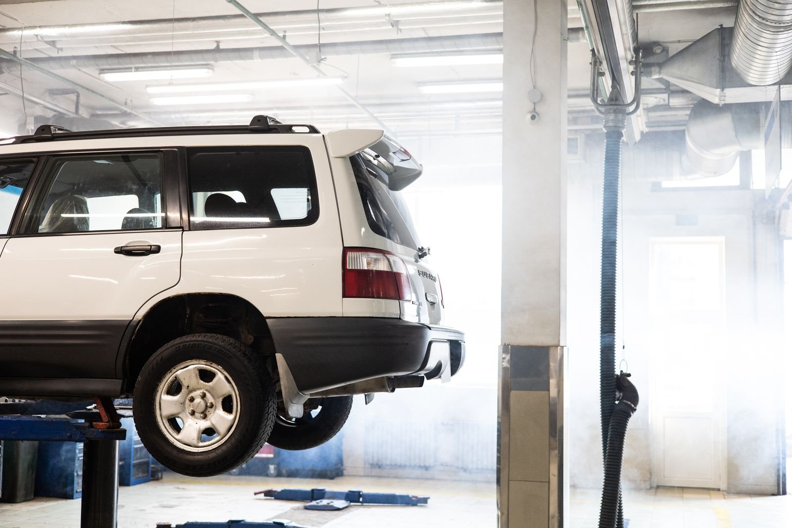 Car raised on a lift in a garage during an MOT test
